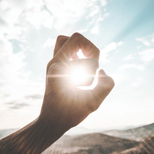 Photo : Une main qui se referme pour ne laisser passer que quelques rayons de soleil