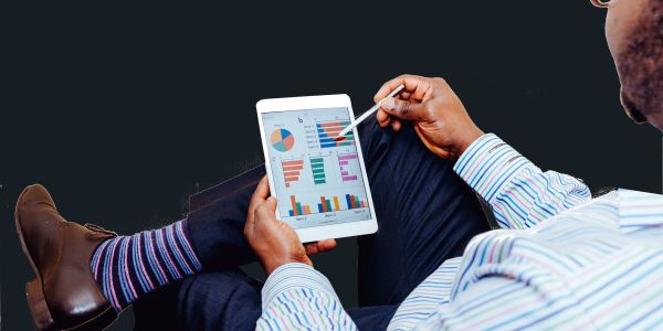 Photo : un homme regardant des résultats clés et des indicateurs sur une tablette