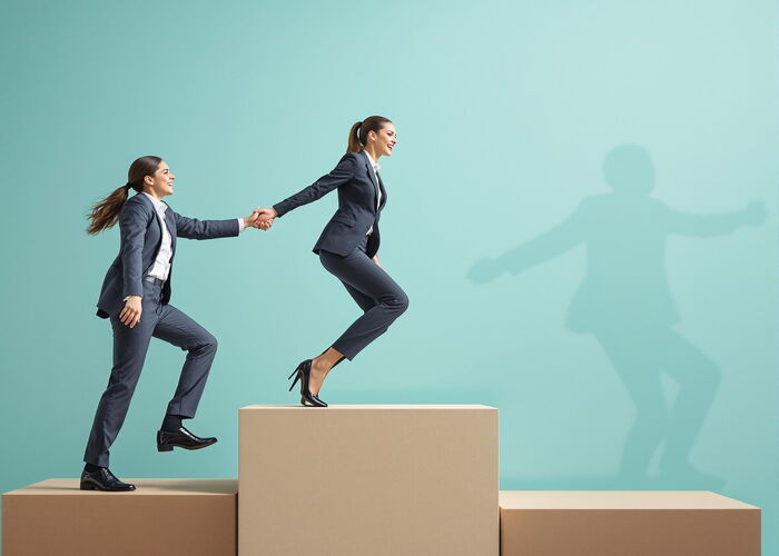 Photo : Une femme manager entrainant une autrepour gravir des marches