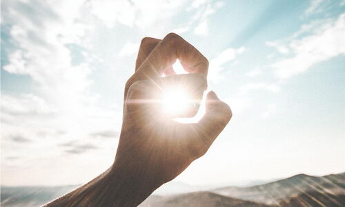 Photo : Une main qui se referme pour ne laisser passer que quelques rayons de soleil