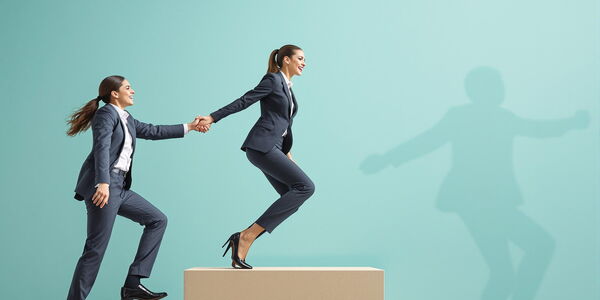 Photo : Une femme manager entrainant une autrepour gravir des marches