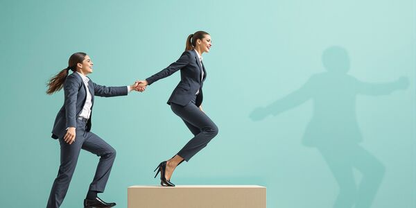 Photo : Une femme manager entrainant une autrepour gravir des marches