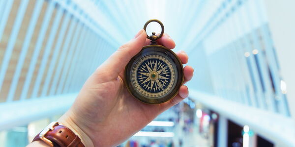 Photo : une personne tenant devant elle une boussole dans son entreprise