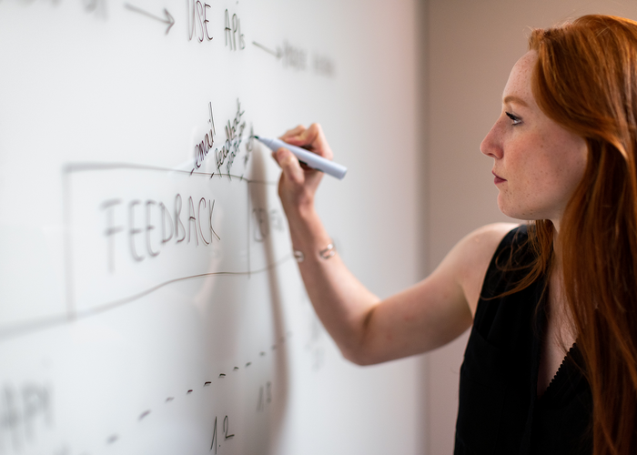Photo : Une Product Manager analysant les usages de son produit sur un tableau blanc